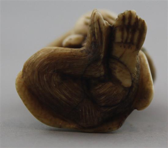 A Japanese ivory netsuke of a seated monkey holding a peach, signed Kogetsu, Meiji period, 3.8cm